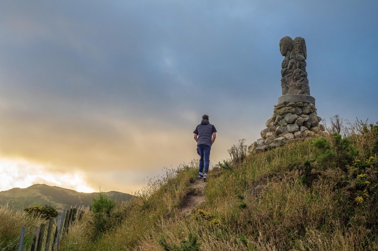 Man walking toward Te Pou at Tawatawa Reserve